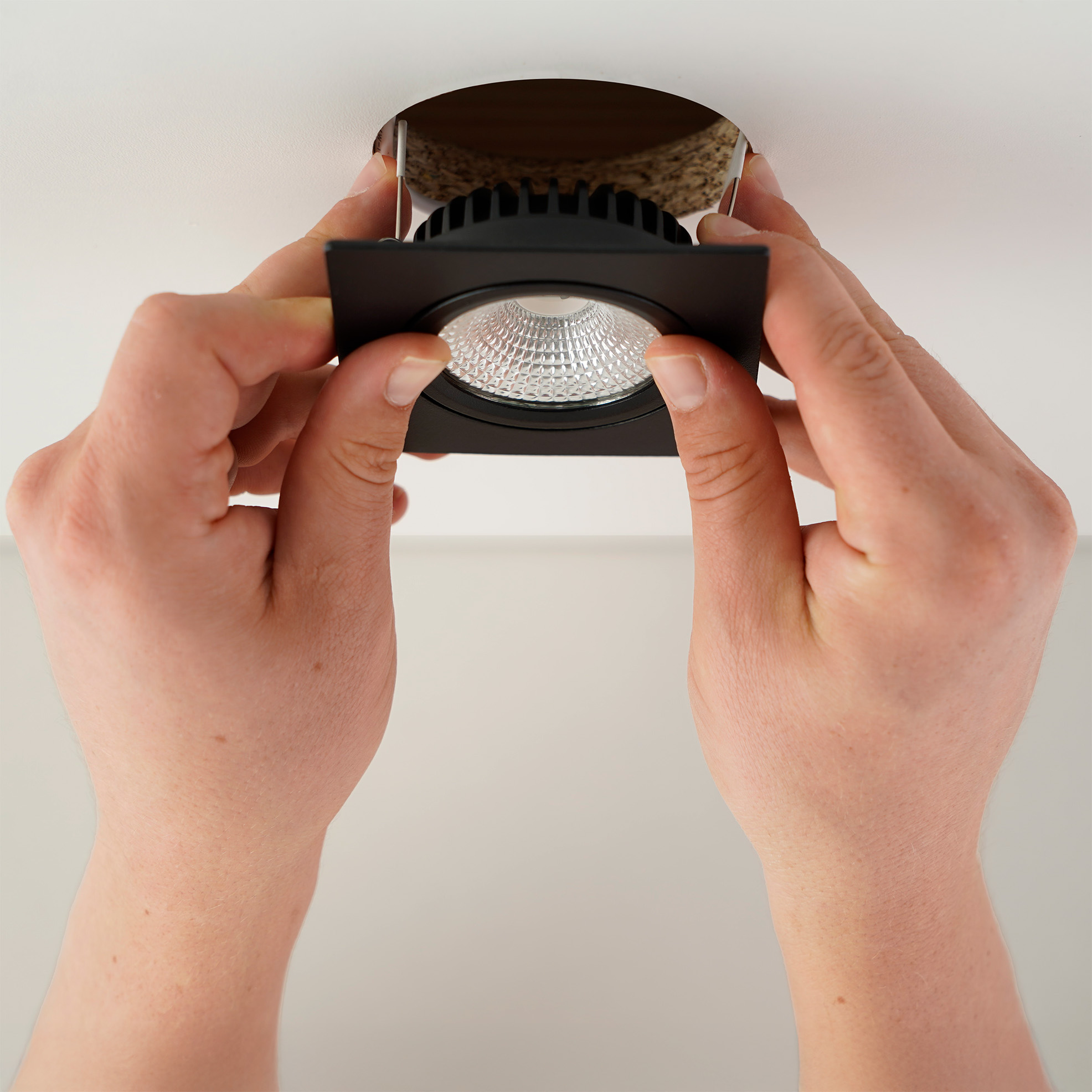 Quadratischer LED Einbaustrahler wird in die Decke eingesetzt fuer einfache Installation