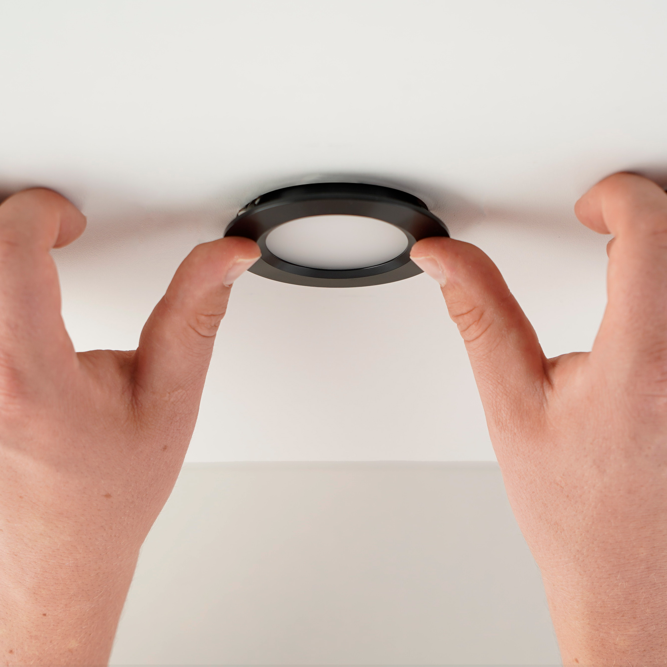 LED Einbaustrahler wird in die Decke eingesetzt indem die Leuchte in die Oeffnung gedrueckt wird