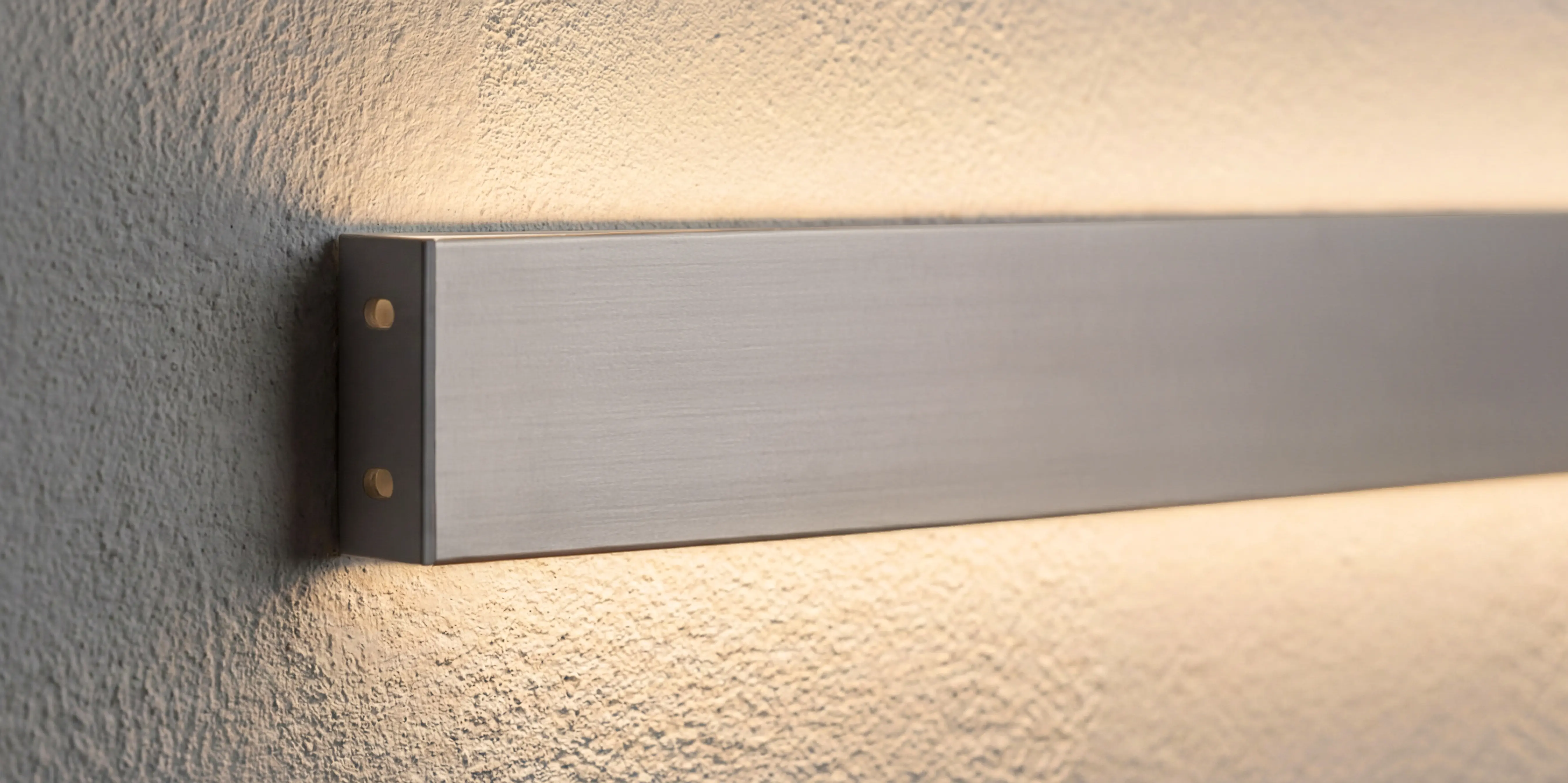 Strak wandprofiel met LED-verlichting die boven en onder warm licht verspreidt voor een modern lichteffect