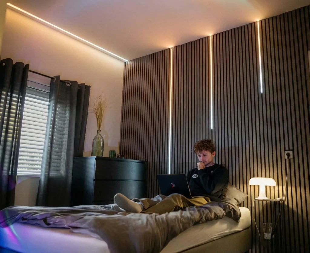 Schlafzimmer mit LED-Streifen in Deckenleiste und Wandpaneel, Dual White fuer klares Licht und warme Stimmung.